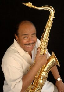 Color photo of Benny Golson holding his saxophone.