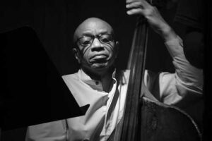 Black and white photo of Reggie Workman playing his bass.